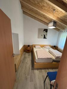 two beds in a room with wooden floors at Casa da Roda in Arronches