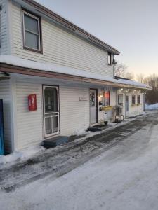 a white building with a street in front of it at acadia sunrise motel in Trenton +13 photos