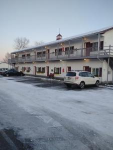 a building with two cars parked in a parking lot at acadia sunrise motel in Trenton