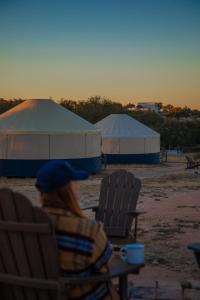 a woman sitting in a chair in front of tents at Johnny Yurts in Johnson City