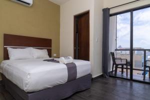 a bedroom with a large bed and a balcony at REGMAR Progreso Yucatán in Progreso
