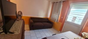 a living room with a couch and a window at La Case Saint-Pierre in Saint-Pierre