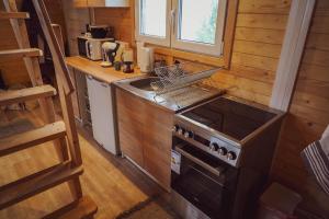 a small kitchen with a stove and a sink at Domek Pod Sosnami in Bronków