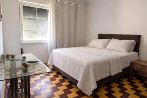 a bedroom with a bed and a glass table at Apto Pet Friendly com Ar condicionado no Centro in Bagé