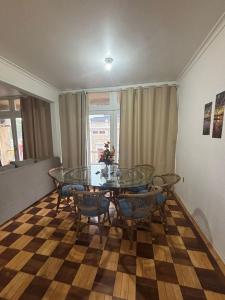 a dining room with a glass table and chairs at Apto Pet Friendly com Ar condicionado no Centro in Bagé