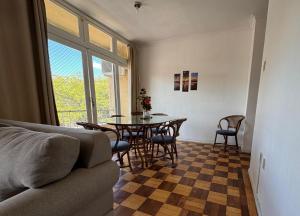 a living room with a table and chairs and a couch at Apto Pet Friendly com Ar condicionado no Centro in Bagé