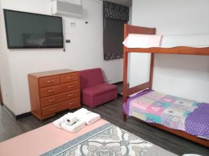 a bedroom with a bunk bed and a chair at Hotel Ruah in Tumbes