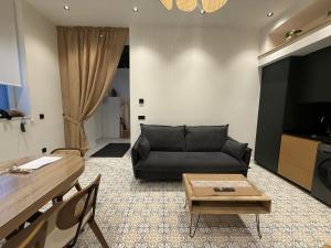 a living room with a black couch and a table at Alojamiento EL ESPOLON in Alba de Tormes