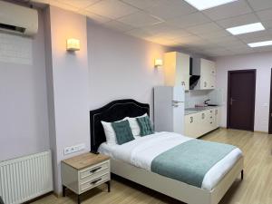 a bedroom with a large bed and a kitchen at Hotel All Time in Tbilisi City
