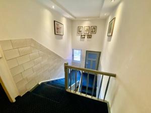 a hallway with a staircase with a blue carpet at Hotel Wahlster in Saarbrücken