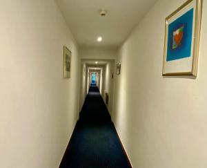 a long hallway with a long hallway at Hotel Wahlster in Saarbrücken +18 photos