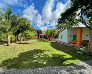 a house with a yard with palm trees at Rancho Doña Rita in Higuey