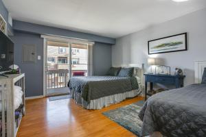 a bedroom with two beds and a window at Steps to Brigantine Beach: New Jersey Beach Condo in Brigantine +25 photos