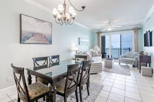 a dining room and living room with a table and chairs at Island Royale 1004 by Youngs Suncoast in Gulf Shores