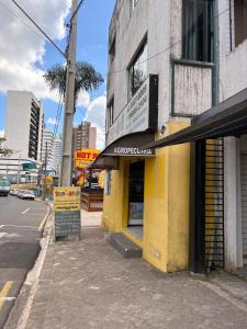 a yellow building with a sign on the side of a street at Apartamentos na região Central Cobertura e 2 quartos in Ponta Grossa