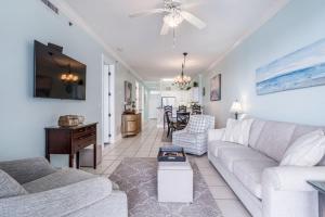 a living room with a white couch and a table at Island Royale 1004 by Youngs Suncoast in Gulf Shores