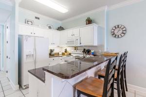a kitchen with white cabinets and a counter top at Island Royale 1004 by Youngs Suncoast in Gulf Shores +40 photos