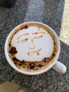a cup of coffee with a face drawn on it at Khufu pyramids boutique hotel in ‘Ezbet `Abd el-Ḥamîd