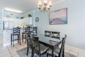 a kitchen and dining room with a table and chairs at Island Royale 1004 by Youngs Suncoast in Gulf Shores