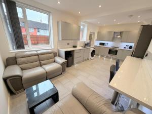 a large living room with a couch and a kitchen at Precious House 4 in Leicester