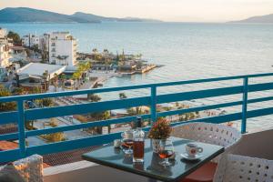 a table on a balcony with a view of the water at Apartments Serxhio in Sarandë