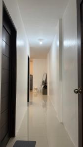 a hallway with white walls and a door and a room at Mabini Homestay in Mabini
