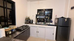 a kitchen with white cabinets and a black refrigerator at Mabini Homestay in Mabini