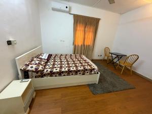 a bedroom with a bed and a table and chairs at Résidence huele in Ouagadougou