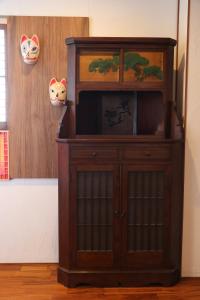 a wooden entertainment center with a television in a room at 京都 大阪アクセス良好の和モダン民泊 静かで快適な宿泊施設です 京阪本線楠葉駅から徒歩圏内 急行特急停車駅で京都へ約30分 大阪へ約40分とアクセス良好です in Hirakata