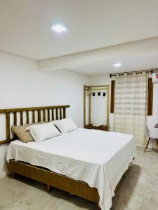 a bedroom with a large white bed in a room at Casa Aura Solis Preá in Prea