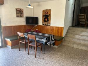 a dining room with a table and chairs and a television at Chalet Doña Ines in Cuesta Blanca