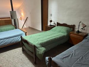 a bedroom with two beds and a table with a lamp at Chalet Doña Ines in Cuesta Blanca