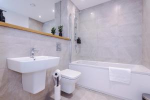 a bathroom with a sink and a toilet and a bath tub at Leeds Lux Apartment - 2 Bed & Pool Table, Secure Parking in Leeds