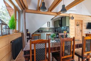 a kitchen and dining room with a wooden table and chairs at Apartamenty Baj na Polnej - bezpłatny parking, widok na góry i zewnętrzna balia! in PyzÃ³wka