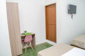 a room with a table and a desk with a pink chair at SGH Hotel San Agustin in Santa Marta