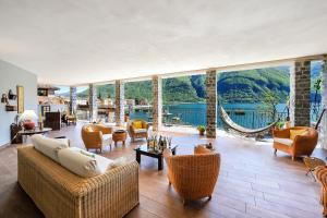 a large living room with a view of the water at La Torre Di Porlezza in Porlezza