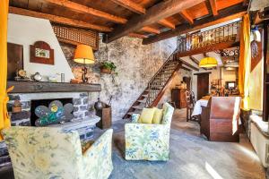 a living room with a stone fireplace and chairs at La Torre Di Porlezza in Porlezza