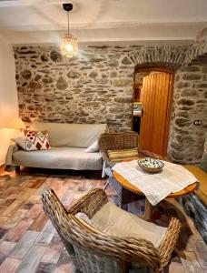 a living room with a bed and a table and chairs at Casa de piedra Siglo XVIII in Badaín