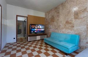 a living room with a blue couch and a flat screen tv at Espaço do Imperador in Petrópolis