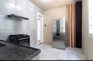 a kitchen with a stainless steel refrigerator and a stove at Espaço do Imperador in Petrópolis
