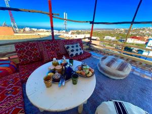 a table with a plate of food on a balcony at Tayri Surf House Aourir in Agadir