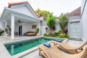 a villa with a swimming pool and a house at Manik Tropicana Loft in Canggu