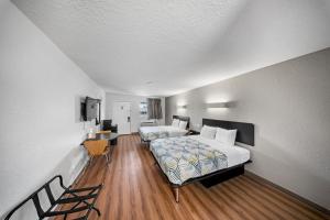 a hotel room with two beds and a table at Motel 6-Moultrie, GA in Moultrie