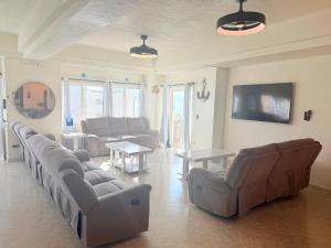 a large living room with couches and a tv at Las Palmas 4BR 4BA Penthouse Ocean View 703 in Campo del Medio