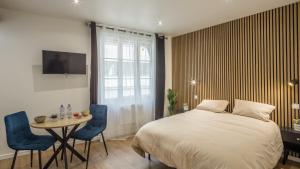 a bedroom with a bed and a table and chairs at Manu Chalons in Chalons en Champagne