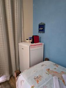 a small refrigerator in a room with a bed at Suite Mar in Ilhabela
