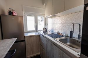 a small kitchen with a sink and a window at Apartman Helena - Self check in in Osijek +18 photos