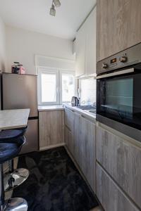 a kitchen with wooden cabinets and a stove top oven at Apartman Helena - Self check in in Osijek