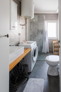 a bathroom with a washing machine and a sink at Apartman Helena - Self check in in Osijek