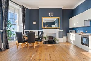 a dining room with blue walls and a table and chairs at Premium Beach Front with Balcony! 2 En-Suites & Spacious By Stay Aura Vacation Rental Brighton & Hove in Brighton & Hove